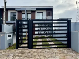 Fachada de uma residência em Lajeado, Brasil com portão de ferro preto.
