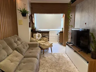 Sala de estar com sofá e decoração em madeira clara.
