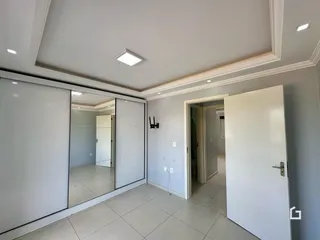 Interior de um corredor com piso de cerâmica e paredes brancas.