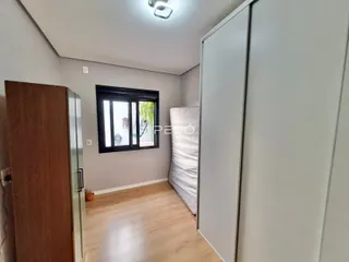 Quarto com piso de madeira clara e armários embutidos.