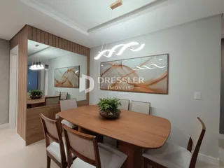 Uma sala de jantar com mesa de madeira e cadeiras.