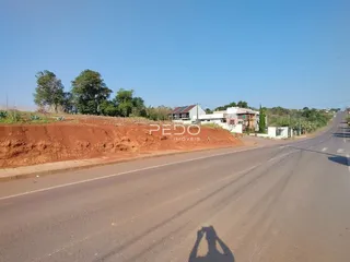 Vista exterior da propriedade mostrando uma estrada e um talude de terra no fundo.