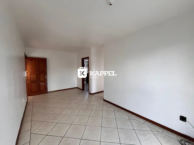Corredor interno com piso de cerâmica e porta de madeira.