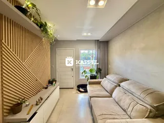 Uma sala de estar moderna com sofá grande e painel de madeira na parede.