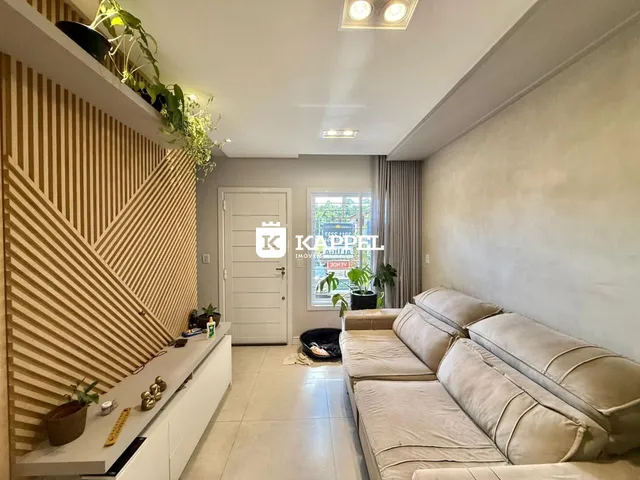 Uma sala de estar moderna com sofá grande e painel de madeira na parede.