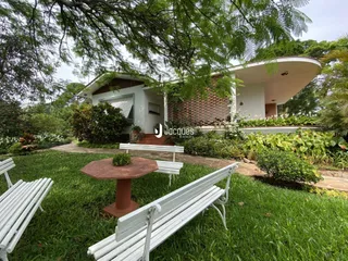 Fachada de uma casa em Lajeado, Brasil, com jardim e bancos no gramado.