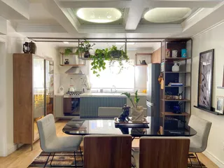 Sala de estar com mesa de jantar e cozinha integrada em um ambiente moderno.