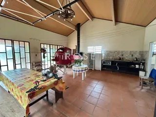 Imagem de um ambiente interno amplo com piso de cerâmica e grandes janelas.