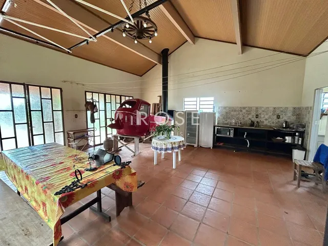 Imagem de um ambiente interno amplo com piso de cerâmica e grandes janelas.