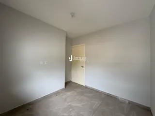 Foto interna de um cômodo com paredes brancas e piso de cerâmica.