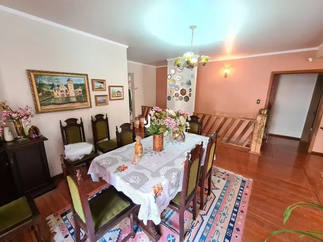 Foto de uma sala de jantar com mesa posta e decoração de parede em Lajeado.