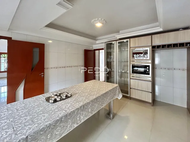 Ambiente interno com mesa de jantar e armários na cozinha.