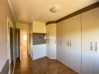 Corredor interno com armários embutidos de cor clara.