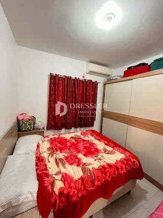 Quarto com cama e guarda-roupa branco.