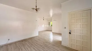 Ambiente interno de uma sala de estar com piso de madeira clara.
