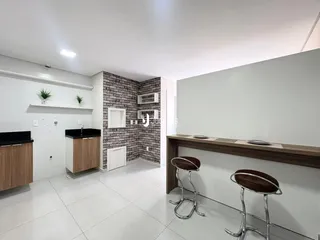 Interior de uma cozinha moderna com piso de cerâmica branca e parede de tijolos expostos.
