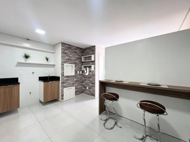 Interior de uma cozinha moderna com piso de cerâmica branca e parede de tijolos expostos.