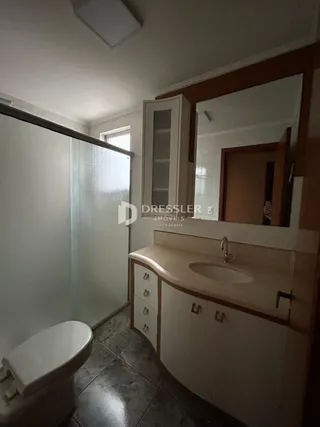 Foto de um banheiro interno com vaso sanitário e box de vidro.