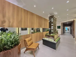 Interior de uma sala com painel de madeira e plantas decorativas.