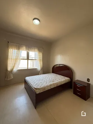 Quarto com cama de madeira e janela iluminada.