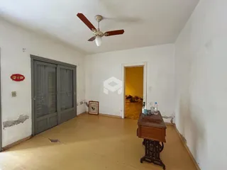 Sala de estar com piso de madeira e porta de madeira.