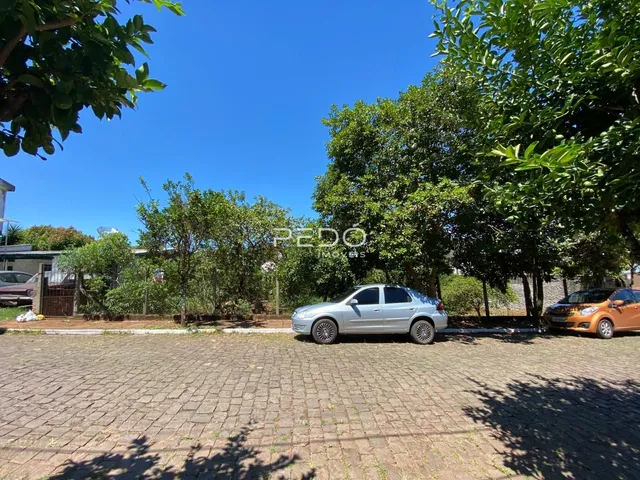 Vista externa de uma propriedade em Lajeado, Brasil, com árvores e veículos estacionados.