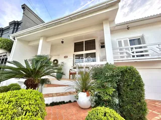 Fachada de uma casa branca com jardim e paisagismo em Lajeado, Brasil.