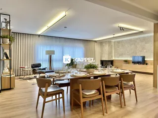 Sala de jantar ampla com mesa de madeira e decoração moderna.
