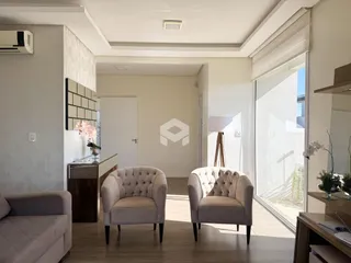 Sala de estar com dois poltronas e piso de madeira clara.