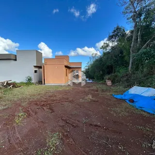 Fachada de uma residência com terreno de terra no primeiro plano