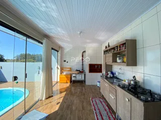 Sala de estar com vista para a piscina e área externa em Lajeado.