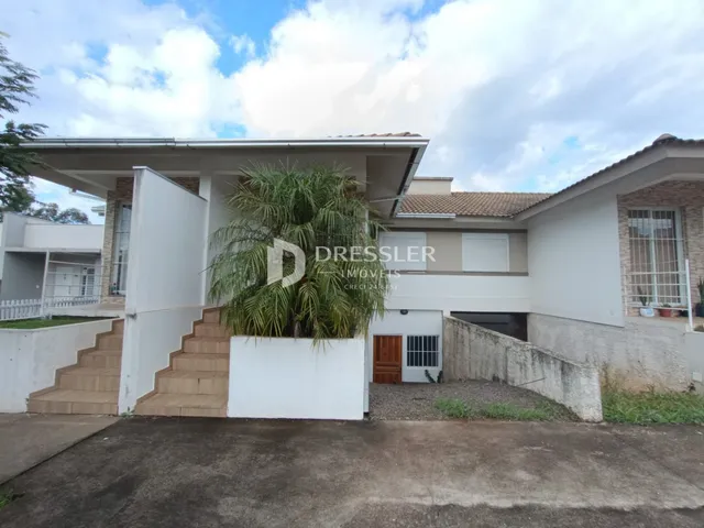 Fachada de uma casa em Lajeado, Brasil, com escadaria e parede branca.