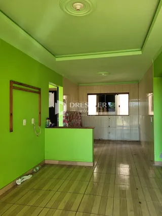 Hall de entrada com paredes verdes e piso de madeira.