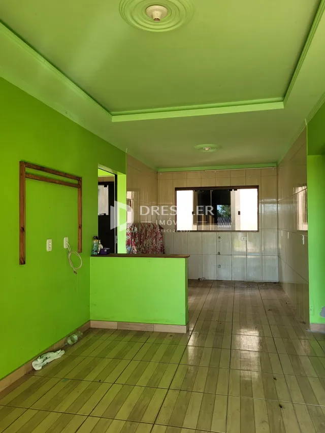 Hall de entrada com paredes verdes e piso de madeira.