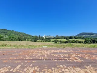 Vista de paisagem de colinas verdes com campo aberto.