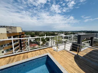 Vista de uma varanda com piscina e vista panorâmica da cidade.