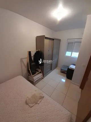 Quarto com cama e armário de roupas em um apartamento.