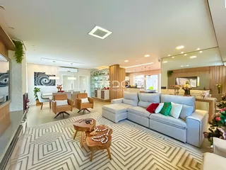 Sala de estar moderna com sofá grande e piso de padrão geométrico.
