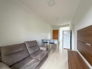Sala de estar com sofá e piso de madeira clara.