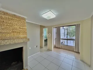 Sala de estar com lareira e porta de entrada iluminada.