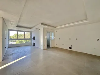Ambiente interno de uma sala ampla com grande janela de vidro.