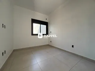 Uma foto de um cômodo interno com paredes brancas e piso de cerâmica.