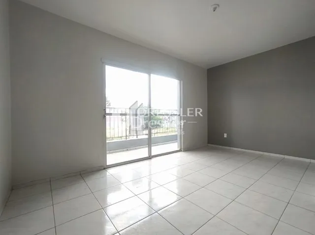 Ambiente interno com piso de cerâmica e grande porta de vidro.