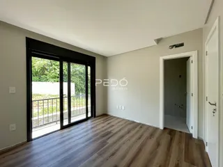 Sala de estar com piso de madeira e porta de vidro que dá para a varanda.