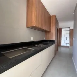 Vista de armários superiores de madeira e bancada escura de uma cozinha.