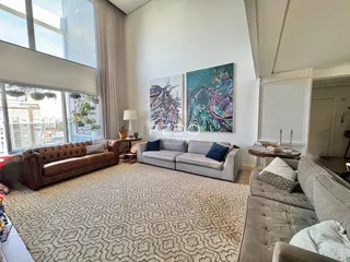 Sala de estar ampla com sofá de couro marrom e decoração moderna.