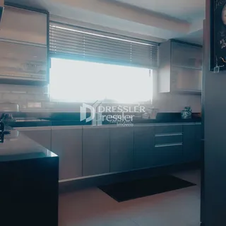 Vista interna de uma cozinha moderna com armários em tons de cinza claro.