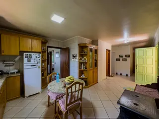 Interior de uma cozinha e sala de jantar com armários de madeira.