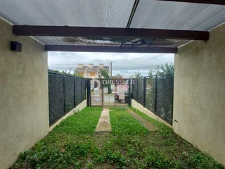 Vista externa de uma propriedade com cerca e gramado.