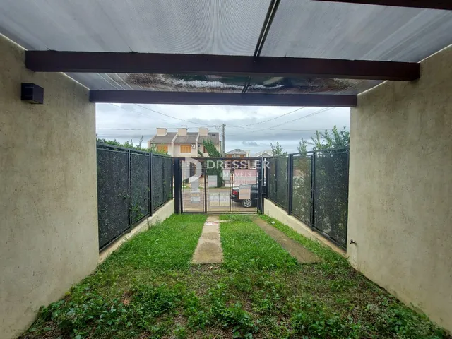 Vista externa de uma propriedade com cerca e gramado.